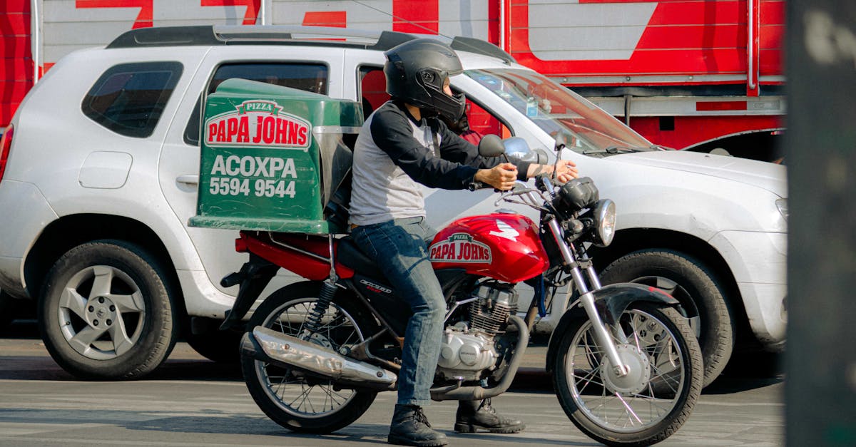 Motoboy entregador de pizza em moto aguardando pedido